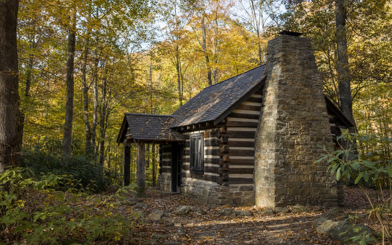 A small Civilian Conservation Corps-era cabin of logs and stone with a big fieldstone chimney among hemlocks and rhododendron, AI-generated illustration