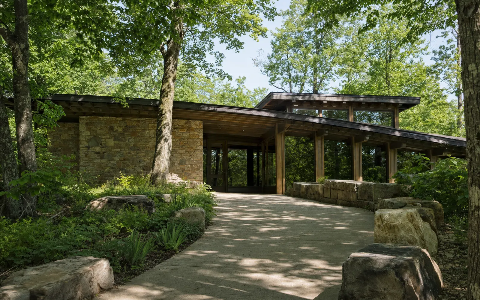 A low contemporary visitor center building of wood and stone set among oaks, a paved walk to its entrance, AI-generated illustration
