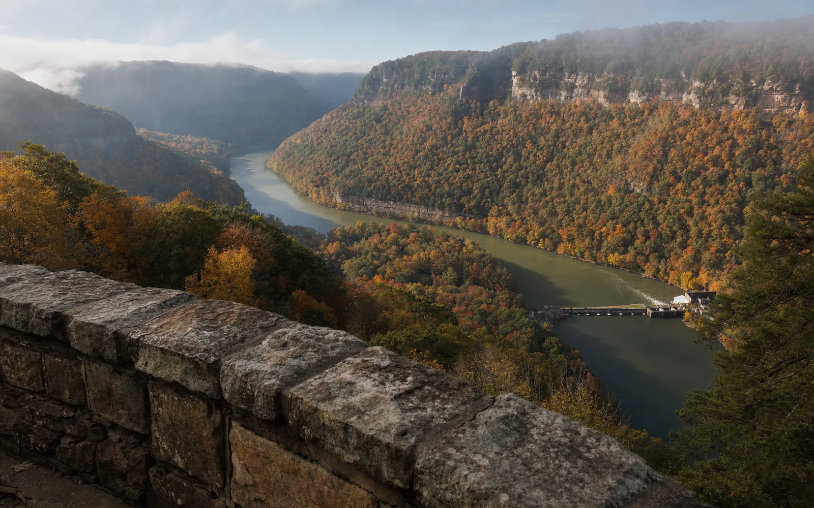 The stone wall of the Hawks Nest overlook above a bend of the New River, with the small dam and lake below and wooded ridges beyond, AI-generated illustration