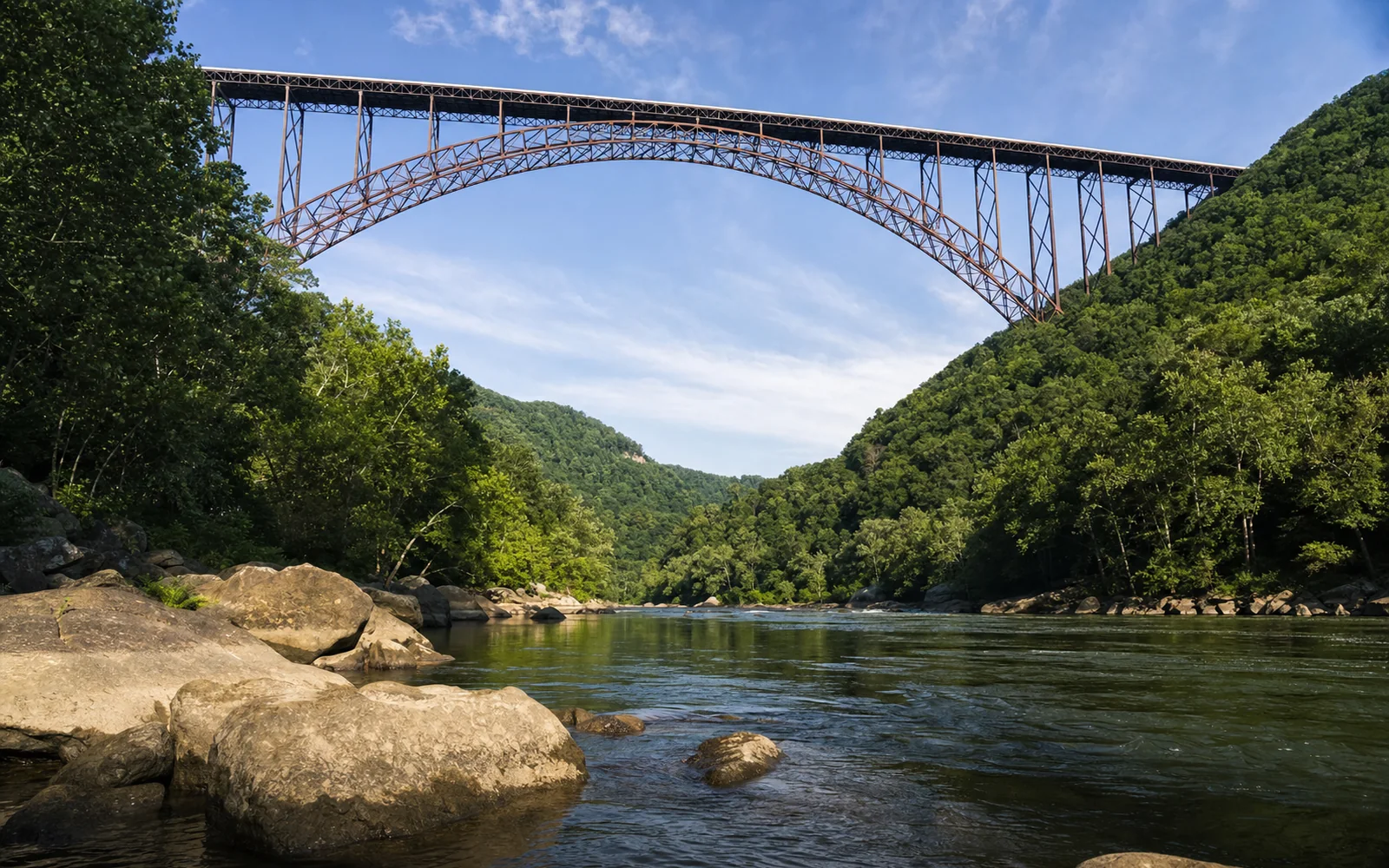 The New River Gorge Bridge seen from river level, the rust-brown steel arch spanning far overhead between the gorge walls, the Lower New's green water and boulders in the foreground, AI-generated illustration