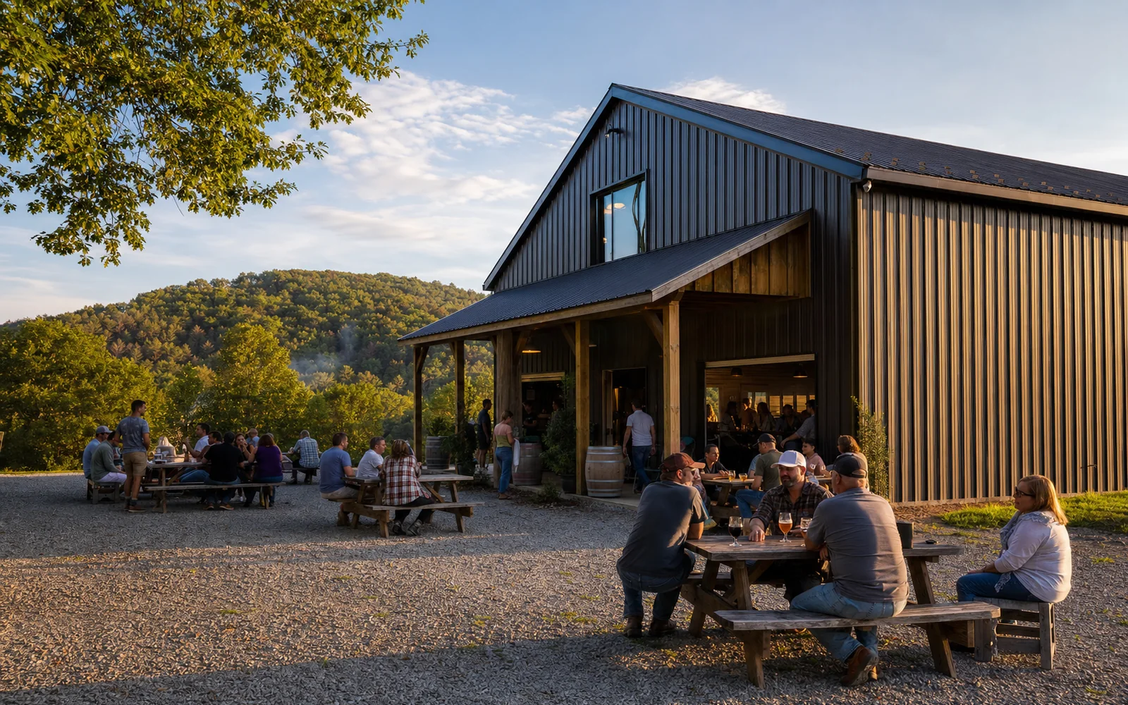 A dark metal barn-style taproom beside a gravel lot, with adults at picnic tables outside and wooded hills behind, AI-generated illustration