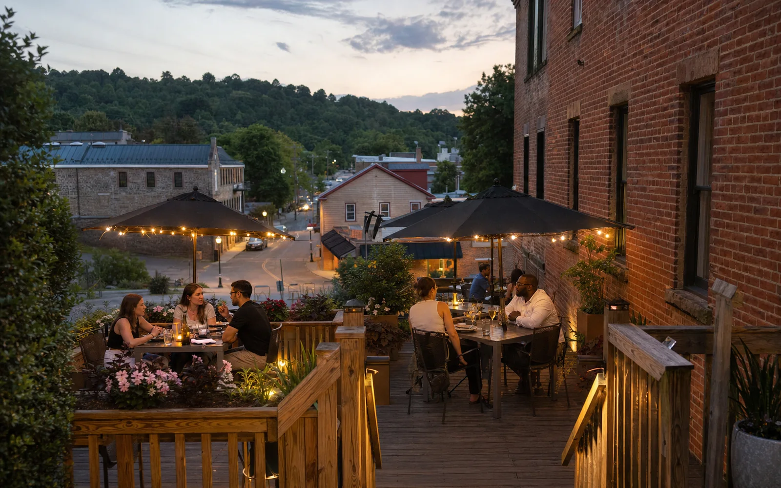 A wooden deck patio with umbrellas behind an old building on a small-town street, a few adults eating, summer evening, AI-generated illustration