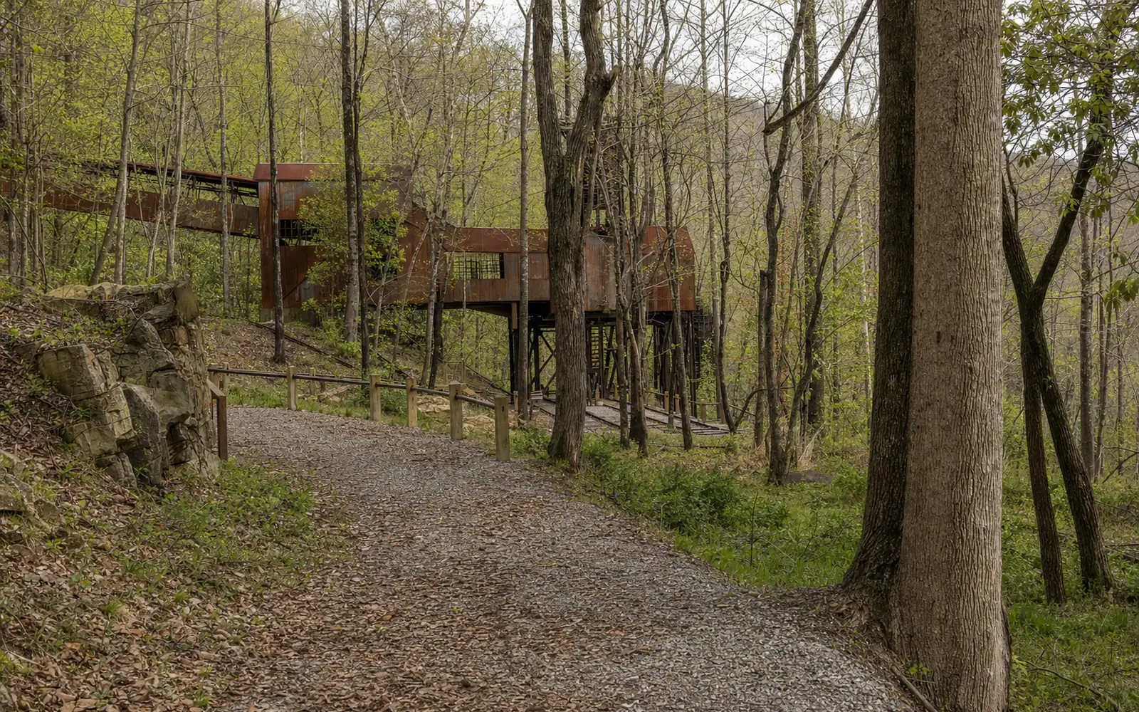 The rusting steel conveyor and tipple at Nuttallburg climbing the forested wall of the New River Gorge, AI-generated illustration