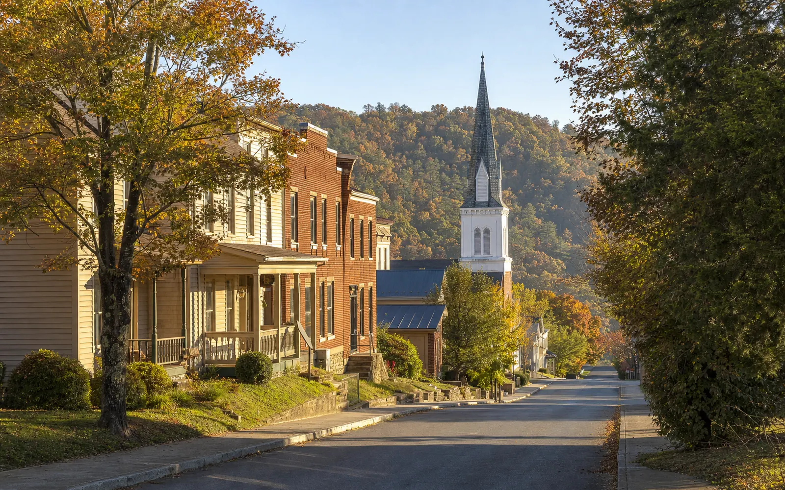A street in the Fayetteville historic district, brick and frame buildings and a church steeple, AI-generated illustration