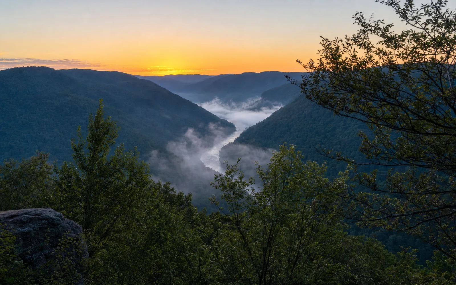New River Gorge seen from Grandview at first light, fog lying in the bend of the river between forested ridges, with no buildings in view, AI-generated illustration