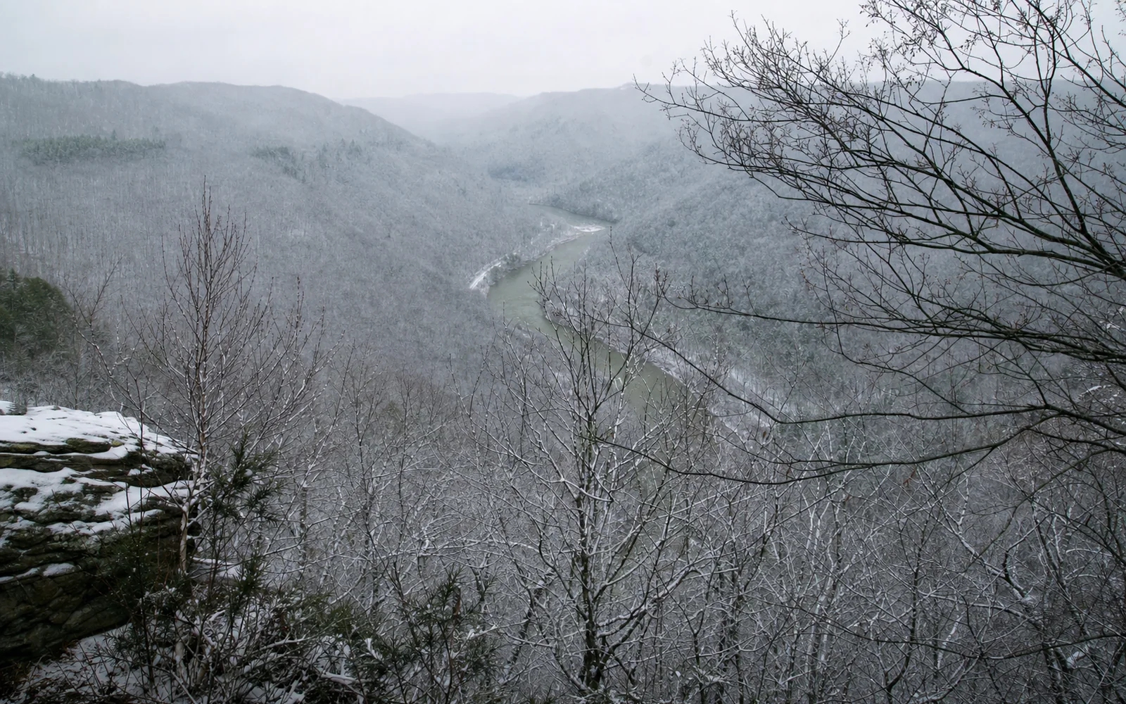 Grandview's main overlook in winter, the horseshoe bend below under snow, bare trees and dark hemlock and rhododendron, AI-generated illustration