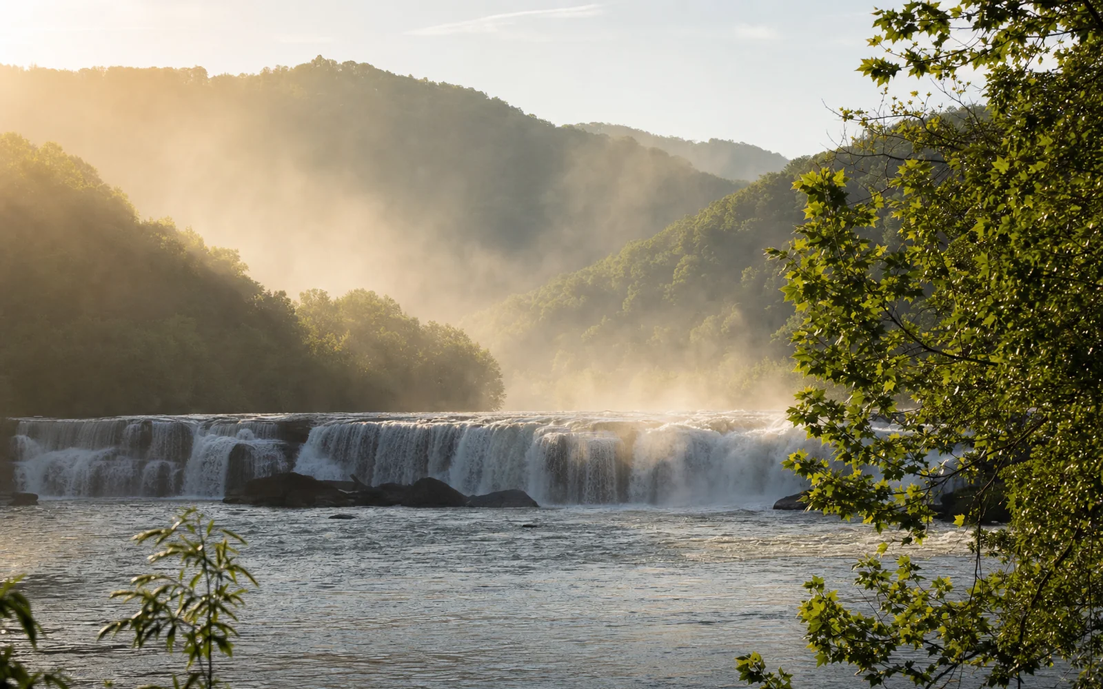 Sandstone Falls seen from the island boardwalk at dawn, the New River breaking over several low sandstone ledges in mist, AI-generated illustration
