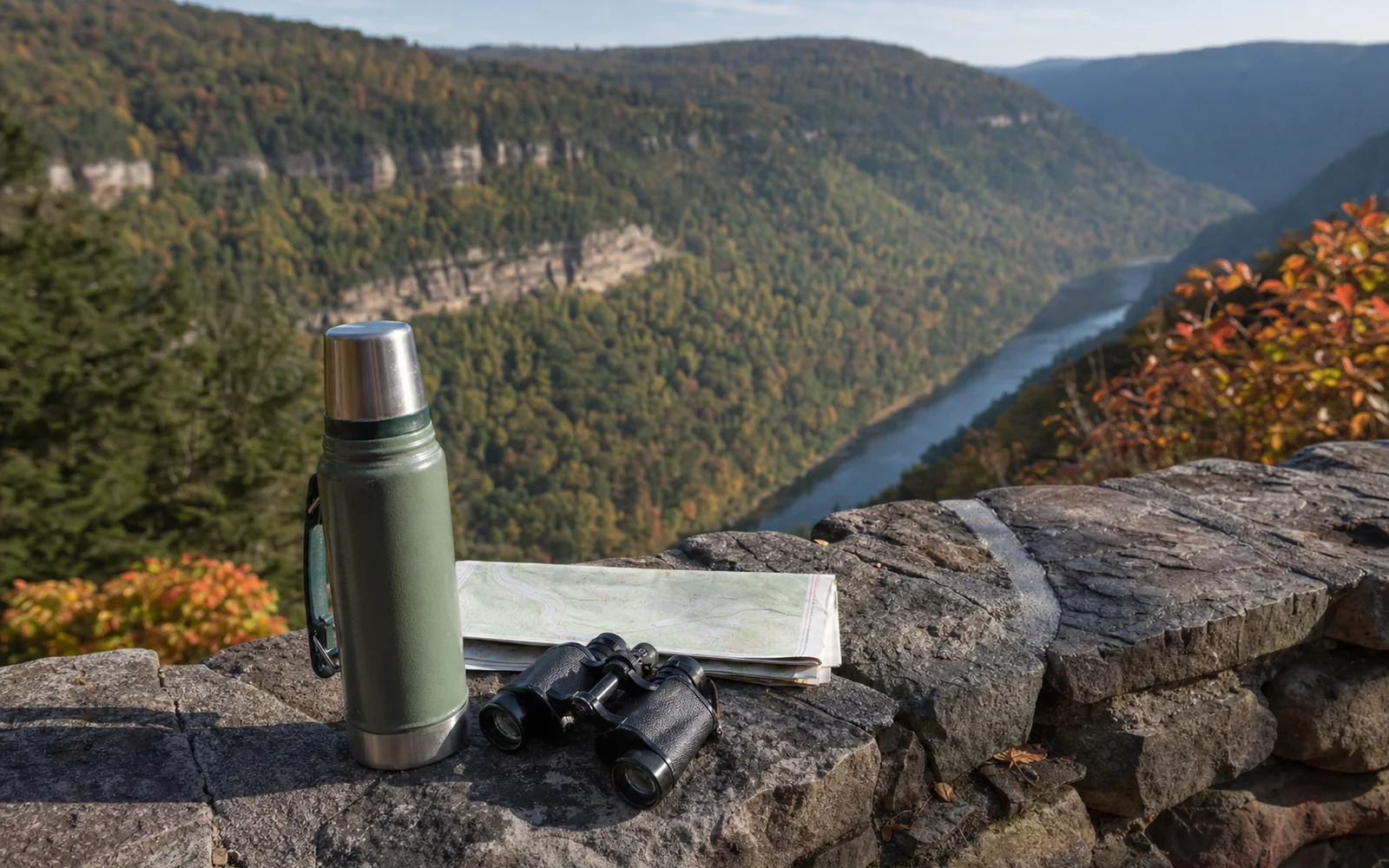 A thermos, binoculars and a folded paper map resting on a stone overlook wall with the gorge beyond, AI-generated illustration