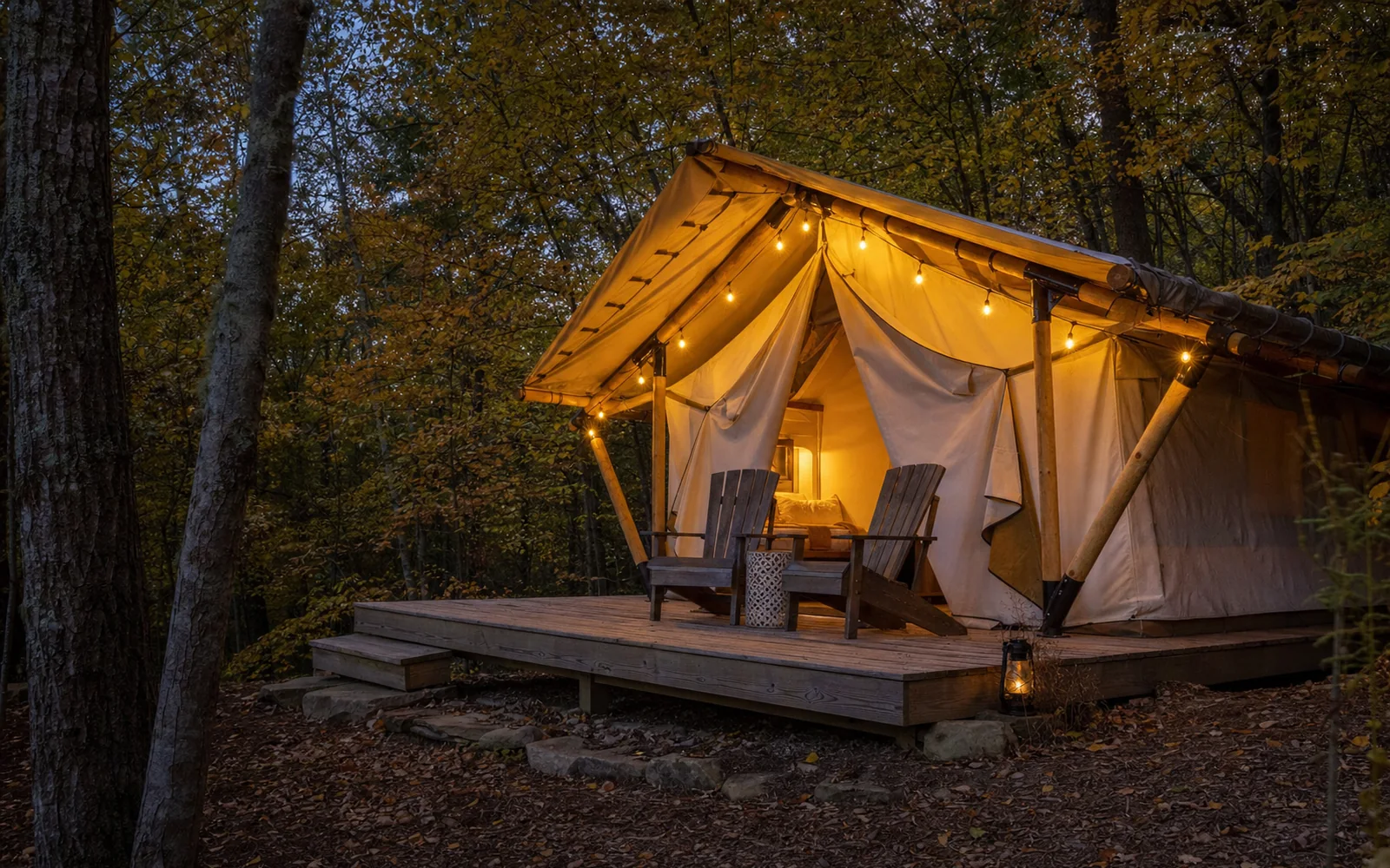 A canvas glamping tent on a raised wooden platform in oak woods, a string of warm lights, two camp chairs on the deck, AI-generated illustration